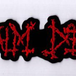 May include: A black patch with the red embroidered text "NAPALM DEATH". The text has a jagged, distressed font style. The patch is rectangular with a black border.