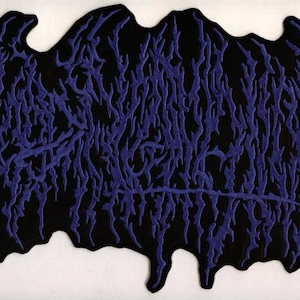 以下が含まれることがあります： 黒いパッチ。濃い青色の、様式化された有機的なデザイン。デザインは、静脈や根のネットワークに似た、テクスチャ加工された隆起した外観をしています。パッチは、ギザギザのエッジを持つ不規則な形状をしています。