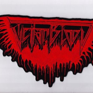 Puede incluir: Un parche bordado en negro y rojo que presenta el texto "Victian Blood" en una fuente estilizada y dentada. El diseño incluye una forma triangular con bordes goteantes en forma de llama que se extienden desde la parte inferior y los lados.