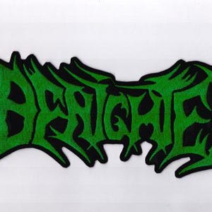 May include: A green and black embroidered patch with the word "DERANGED" in a stylized, gothic font. The patch has a jagged, irregular border and is likely for clothing or accessories.