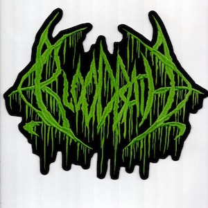 May include: A black patch with the word "BLOODRAT" embroidered in bright green, stylized with dripping, organic shapes. The patch has a jagged, irregular border.