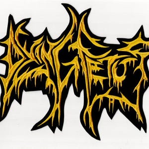 Op de afbeelding: Zwarte patch met gele geborduurde tekst. De tekst, waarschijnlijk een bandnaam of logo, is geschreven in een gestileerd, druipend lettertype. De patch heeft een onregelmatige, gekartelde vorm en is bedoeld voor kleding of accessoires.