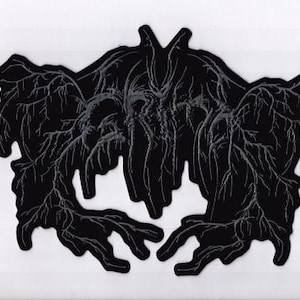 May include: Black abstract design resembling a Rorschach inkblot test. The symmetrical shape features intricate vein-like details in a lighter shade against a solid black background. The design is centered on a white background.