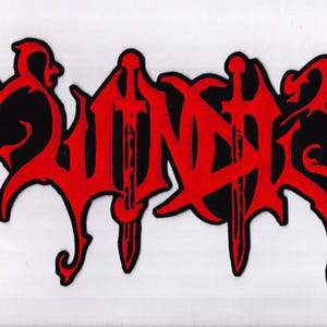 May include: A red and black patch featuring the word "Winds" in a stylized font. The letters are in red with a black outline, and the design includes two sword-like elements. The patch has a gothic or metal aesthetic.