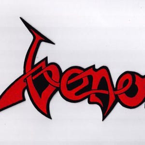 May include: The word "Venom" in a stylized, red font with black accents. The lettering has sharp angles and a gothic aesthetic, set against a white background. The design is bold and eye-catching.