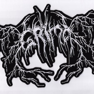 May include: A black and white embroidered patch with an abstract design. The patch has a black base with a detailed white pattern resembling veins. The design is symmetrical and intricate, suitable for clothing or accessories.