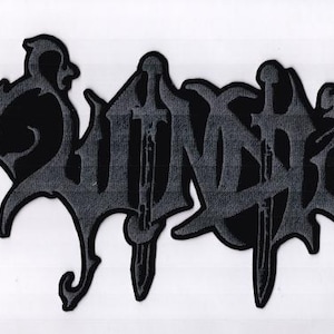 May include: A black and gray patch featuring the word "WOUND" in a gothic font. The design includes stylized shapes and sword-like elements, suitable for clothing or accessories.
