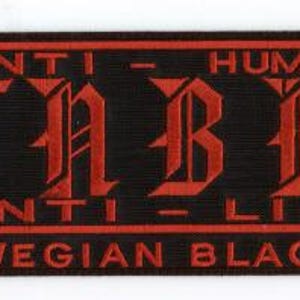 May include: Black rectangular patch with red text and symbols. The text reads "ANTI - HUMAN, ANTI - LIFE" and "TRUE NORWEGIAN BLACK METAL!!!". Symbols include a cross, a snake, a thumbs down, and a skull with crossbones.