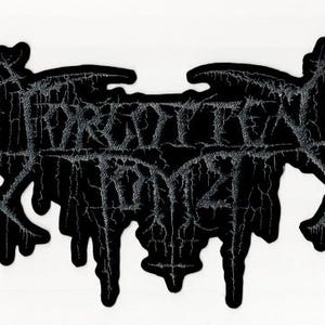 May include: Black patch with the text "FORGOTTEN TOMBS" in a gothic font. The patch has a unique, irregular shape with a dripping effect at the bottom. The text is in a distressed, textured style, adding to the patch's aesthetic.