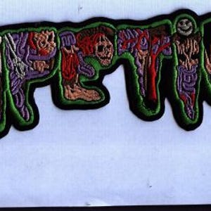 Könnte beinhalten: Ein schwarzer Aufnäher mit dem Wort "FETID" in einem tropfenden, grotesken Stil. Die Buchstaben sind mit Bildern von freiliegendem Fleisch, Organen und einem Schädel gefüllt, umrandet in Grün und Schwarz. Ein lächelndes Gesicht ist in das Design integriert.