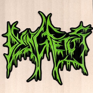 May include: Embroidered patch with the word "DEATHROT" in a stylized, dripping green font on a black background. The patch has a jagged, irregular shape and is likely designed for application on clothing or accessories.