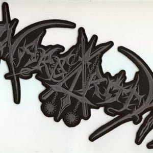 Könnte beinhalten: Zwei schwarz-graue, gestickte Aufnäher mit einem gotischen Design. Die Aufnäher weisen stilisierte Schriftzüge und komplizierte Details auf, darunter kettenartige Elemente und sichelförmige Formen. Die Aufnäher sind wahrscheinlich für Kleidung oder Accessoires bestimmt.