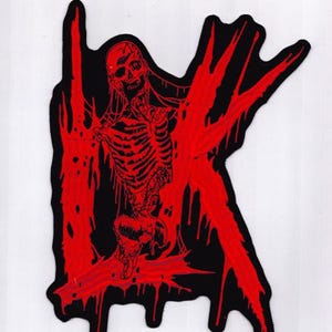 Puede incluir: Un parche negro con una ilustración roja de un esqueleto. La imagen muestra un cráneo, costillas y columna vertebral. La figura está rodeada de formas rojas goteantes, creando un diseño de temática de terror.