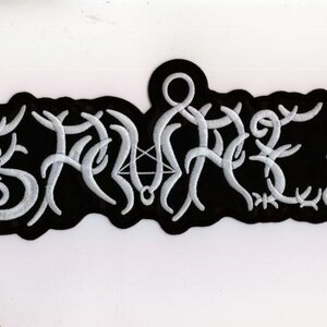 Könnte beinhalten: Schwarzer, gestickter Aufnäher mit weißer, stilisierter Schrift. Der Aufnäher hat eine unregelmäßige Form. Das Design zeigt ein Pentagramm und andere Symbole. Der Aufnäher ist wahrscheinlich für Kleidung oder Accessoires.