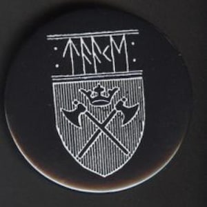 Pode incluir: Um emblema preto e circular com um design branco gravado. O design inclui um escudo com machados cruzados, uma coroa e linhas verticais. Acima do escudo estão símbolos e texto.