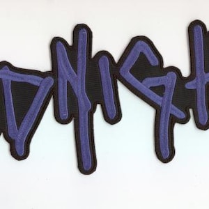 Könnte beinhalten: Ein schwarzer Aufnäher mit dem Wort "MIDNIGHT" in stilisierten, tropfenden lila Buchstaben. Die Buchstaben haben eine dunkelviolette Umrandung, und der Aufnäher befindet sich auf einem weißen Hintergrund. Das Design hat eine Graffiti- oder Streetart-Ästhetik.