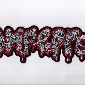 Op de afbeelding: Geborduurde patch met het woord "EMPEROR" in een gestileerd, druipend lettertype. De tekst is wit met rode accenten en een zwarte rand. Het ontwerp heeft een gotisch of horror thema.