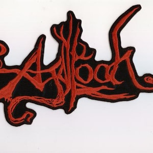 May include: A black patch with the word "Afrood" embroidered in red, stylized lettering. The patch has an irregular shape and is likely for clothing or accessories.