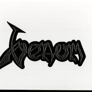 Puede incluir: Parche en blanco y negro con la palabra "Venom" en una fuente gótica estilizada. El texto tiene un efecto sombreado y texturizado, con contorno negro. Ideal para ropa o accesorios.