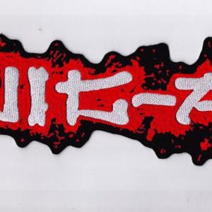 May include: A rectangular patch with a black border and a red interior. The patch features white Japanese characters. The overall design has a distressed, textured appearance, with the red colour bleeding into the black border.