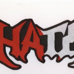 Könnte beinhalten: Gestickter Aufnäher mit dem Wort "HATE" in einer stilisierten Schriftart. Die Buchstaben "HA" sind rot mit schwarzen Umrissen, während "TE" weiß mit schwarzen Umrissen ist. Der Aufnäher hat einen schwarzen Rand.