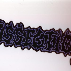 Op de afbeelding: Een zwarte patch met het woord "Dissection" in een gestileerd, gotisch lettertype. De tekst is omlijnd in paars, met een bijpassende paarse rand. De patch heeft een decoratief, sierlijk ontwerp.