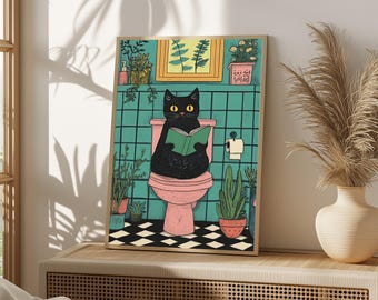 May include: A framed wall art print featuring a black cat with yellow eyes sitting on a pink toilet in a bathroom with teal tiled walls, reading a green book. The floor has a black and white checkered pattern, and various potted plants are visible.