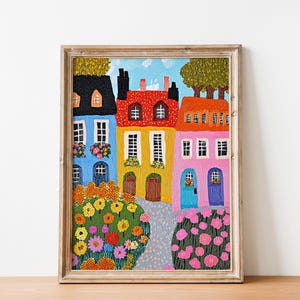 Pu&ograve; includere: Un dipinto che rappresenta una fila di case colorate con alberi verdi e fiori davanti. Le case sono dipinte in tonalit&agrave; di blu, giallo, rosso e rosa. I fiori sono un mix di giallo, arancione, rosso e rosa.