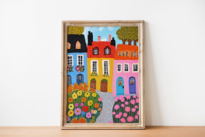 Pu&ograve; includere: Un dipinto che rappresenta una fila di case colorate con alberi verdi e fiori davanti. Le case sono dipinte in tonalit&agrave; di blu, giallo, rosso e rosa. I fiori sono un mix di giallo, arancione, rosso e rosa.