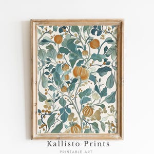 May include: A framed print featuring a botanical illustration of a leafy branch with orange and yellow fruit. The background is a cream color and the leaves are a deep teal green.