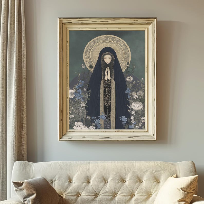 May include: Framed art print featuring a figure in a dark blue cloak with hands clasped in prayer, surrounded by flowers in shades of blue and white. The artwork has a gold halo and is set against a teal background. The frame is a distressed off-white color.