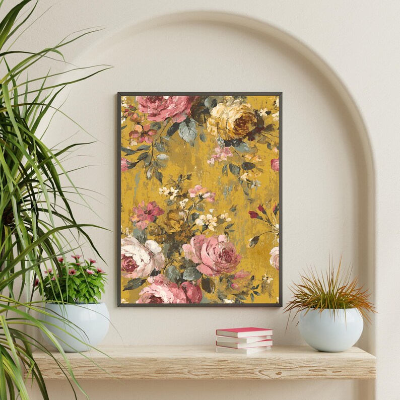 May include: A framed floral print featuring a vintage-style design. The artwork showcases a bouquet of pink, white, and yellow roses against a textured, mustard-yellow background. The print is displayed on a wooden shelf with potted plants.