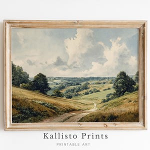Op de afbeelding: Ingelijste kunstafdruk met een serene landschapsscène. Het kunstwerk toont glooiende heuvels, een kronkelende zandweg en een bewolkte lucht. De afdruk zit in een lichtgekleurde houten lijst. De tekst "Kallisto Prints Printable Art" staat onderaan.