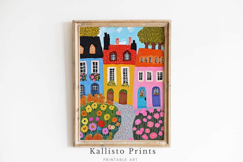 Pu&ograve; includere: Un dipinto colorato di una fila di case con pareti rosse, gialle, blu e rosa. Le case hanno finestre e porte, e ci sono fiori davanti a loro. Il dipinto &egrave; incorniciato in una cornice di legno chiaro.