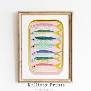 May include: A framed print showing a colourful illustration of sardines in a can. The sardines are in shades of pink, green, and blue, with yellow tail fins. The print is set against a pink background.