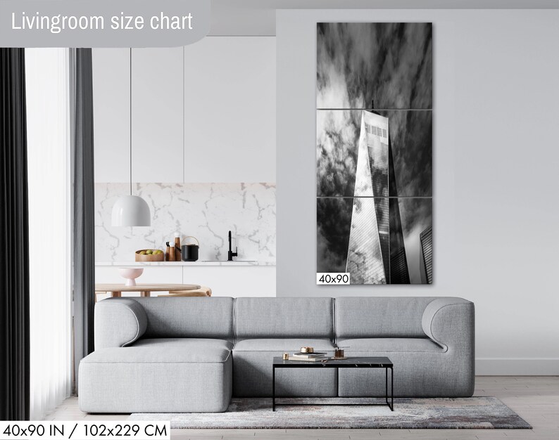 Puede incluir: Tr&iacute;ptico en blanco y negro que representa un rascacielos contra un cielo nublado. La obra de arte se exhibe sobre un sof&aacute; gris en un sal&oacute;n moderno. Las dimensiones del lienzo son 102x229 cm.