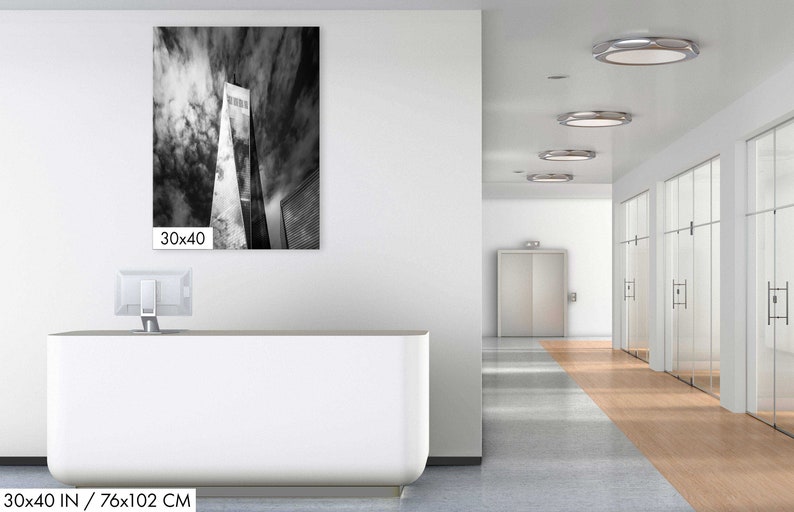Puede incluir: Fotograf&iacute;a en blanco y negro de un edificio alto contra un cielo nublado. La imagen se muestra en una pared en un entorno de oficina. Las dimensiones de la impresi&oacute;n son 76x102 cm.