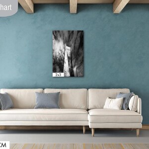 Puede incluir: Un sal&oacute;n moderno con una pared color turquesa, un sof&aacute; seccional color crema y una obra de arte abstracta en blanco y negro. La obra de arte mide 61x91 cm. La habitaci&oacute;n tambi&eacute;n cuenta con una puerta de madera y una peque&ntilde;a mesa auxiliar.
