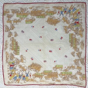 May include: Vintage white handkerchief with a red border, featuring a detailed illustration of military vehicles, soldiers, and flags in shades of brown, green, and blue. The handkerchief has the text "U.S.A." on some of the vehicles.