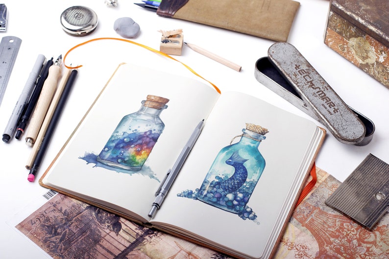 Puede incluir: Un cuaderno de bocetos abierto con dos pinturas de acuarela de botellas de vidrio. La botella de la izquierda contiene un arco&iacute;ris y remolinos azules. La botella de la derecha contiene un pez azul y cuentas azules y blancas.