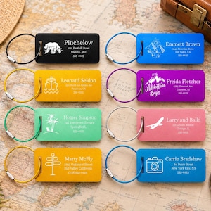 May include: A selection of vibrant luggage tags, each featuring a different design and name, such as a bear, mountains, a ship, palm trees, a signpost, a camera, and an airplane. They all have a metal loop.