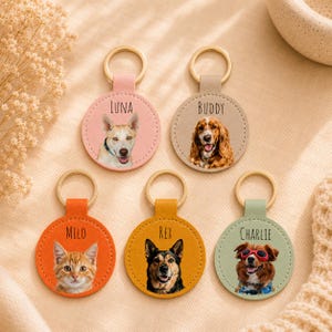 May include: Five personalized pet keychains with gold-colored rings. Each keychain features a different pet portrait and name: Luna, Buddy, Milo, Rex, and Charlie. The keychains are in various colors, including pink, tan, orange, yellow, and green.