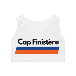 May include: White sports bra with the text "Cap Finistère" in black, above a blue and orange stripe. The bra has a scoop neck and is made of a smooth, likely athletic fabric.