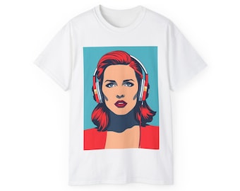 Puede incluir: Camiseta blanca con una ilustración de estilo pop art de una mujer con pelo rojo y auriculares. El retrato de la mujer está sobre un fondo turquesa, con una parte superior roja. Los auriculares tienen detalles en rojo y amarillo.