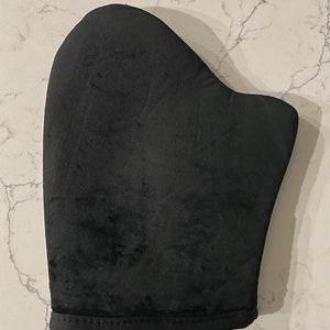 May include: Black self-tanning mitt for applying self-tanner evenly to the skin.