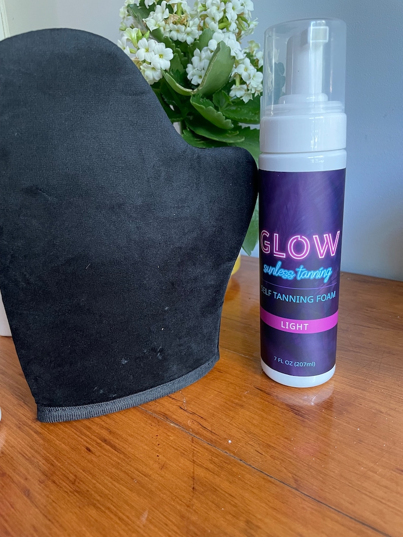 May include: A black tanning mitt and a bottle of self tanning foam labeled "GLOW sunless tanning SELF TANNING FOAM LIGHT 7 FL OZ (207ml)"