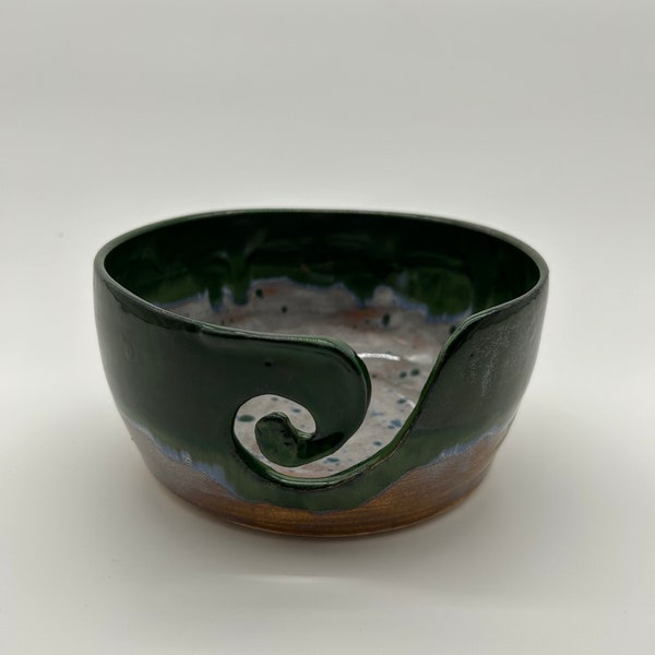Handthrown pottery yarn bowl, hand cut curvature. Glaze has run to produce beautiful pale green and blue colours that flow into sepia glaze.