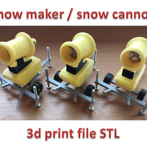 Puede incluir: Tres cañones de nieve amarillos sobre una base de metal gris con ruedas negras. Los cañones de nieve están impresos en 3D y el texto "3d print file STL" está debajo de la imagen.