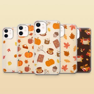 May include: Five clear smartphone cases arranged in a row, each featuring a repeating pattern of autumn-themed illustrations including orange pumpkins, brown acorns, red and yellow maple leaves, books, and mugs of warm beverages on light backgrounds.