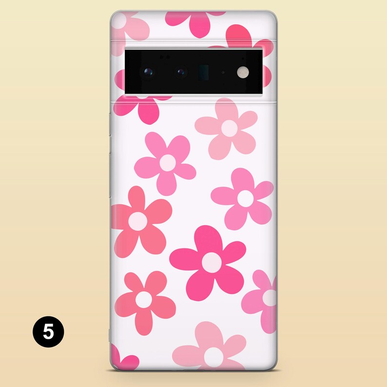 Pode incluir: Uma capa de telefone branca com um padr&atilde;o floral rosa e branco. A capa tem um recorte para a lente da c&acirc;mera.